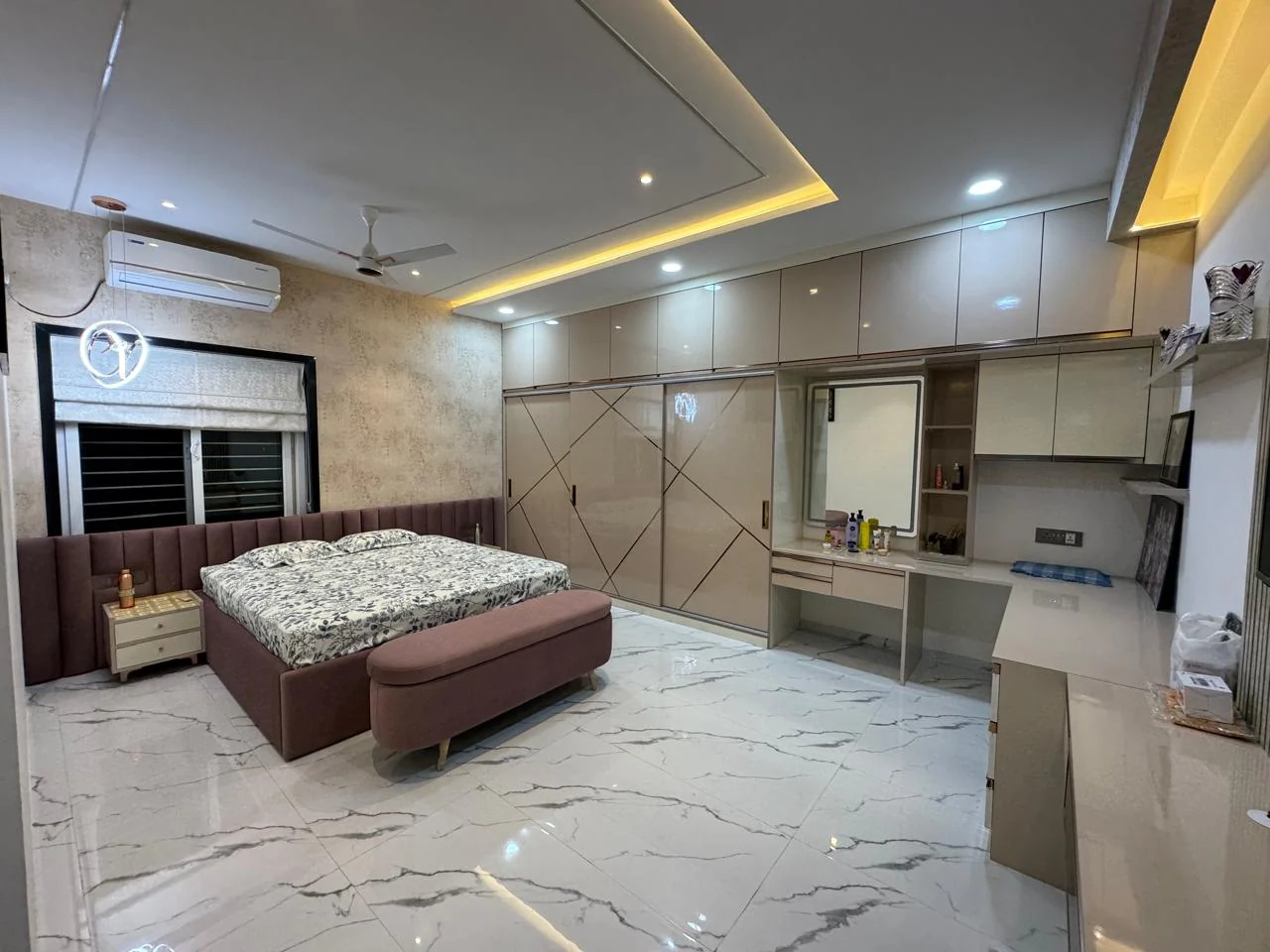 Bedroom with a full wall of gloss wardrobes and an integrated dressing unit