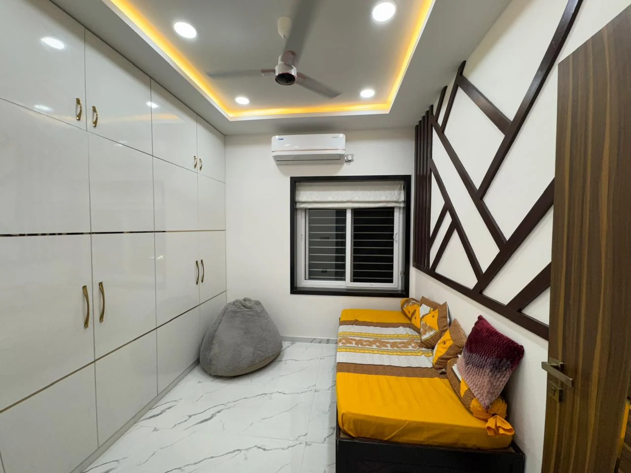 Bedroom with gloss wardrobes beside a timber batten feature wall