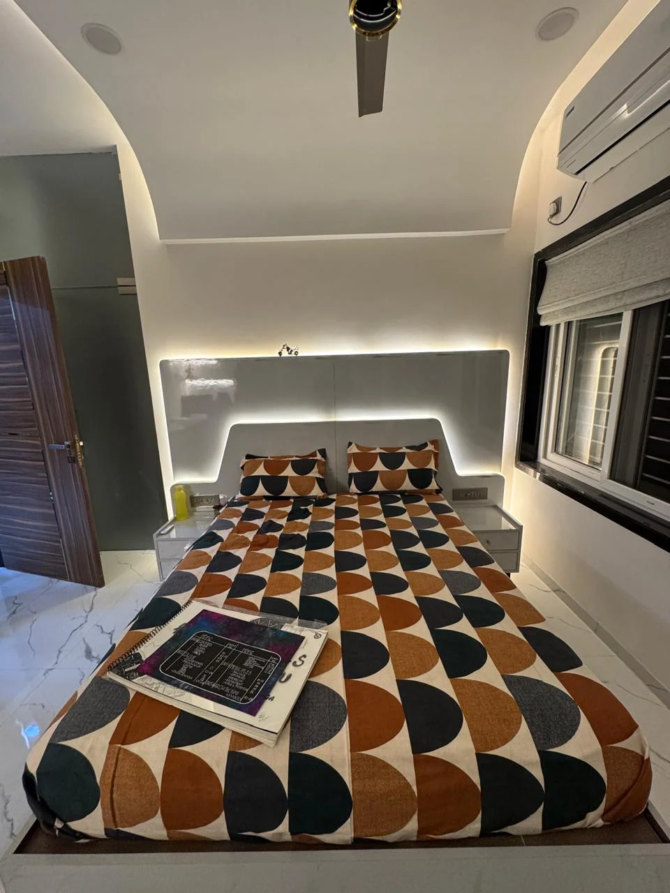 Alternate view of a bedroom with a lit headboard recess
