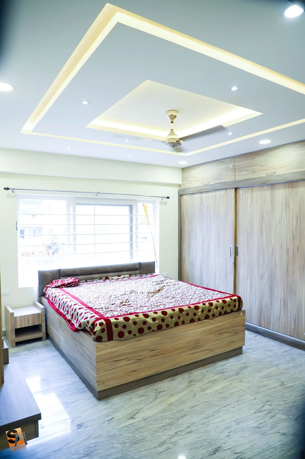 Bedroom with a recessed cove ceiling above a timber wardrobe and bed