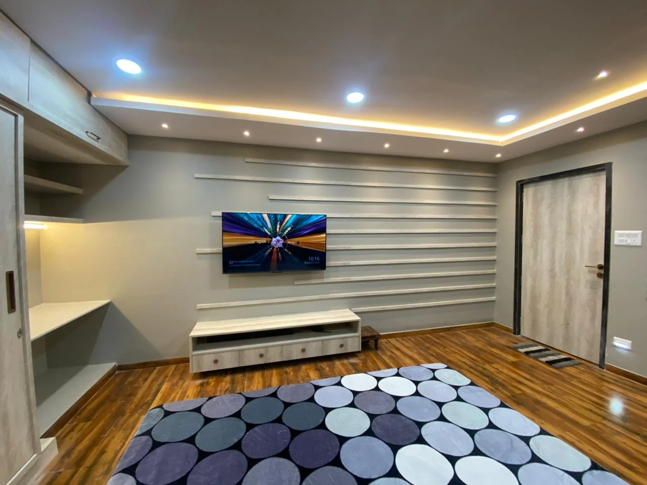 Bedroom slat wall with a floating television console above a timber floor