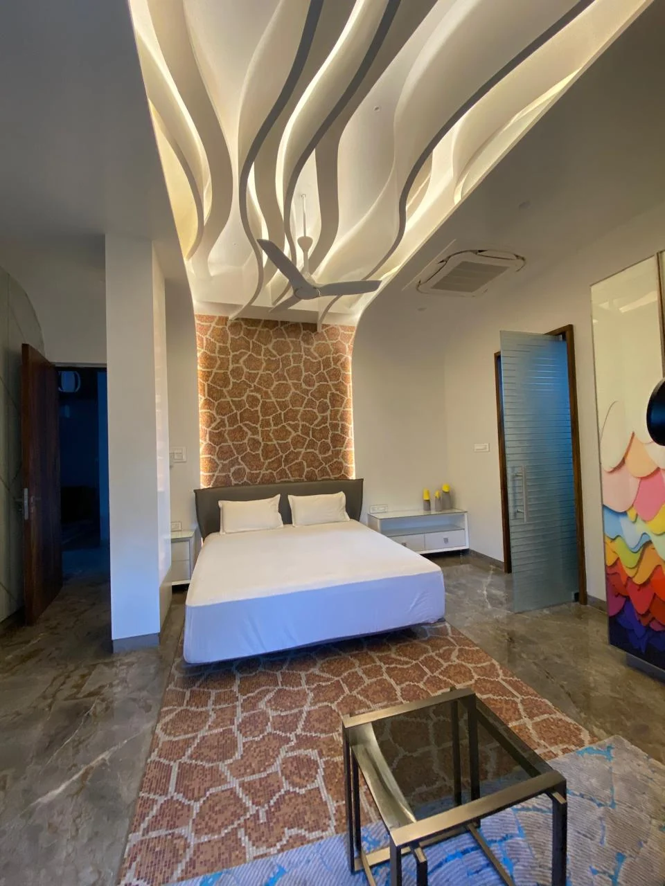 Bedroom with a split-face stone headboard wall and an arched cove ceiling curving down to meet it
