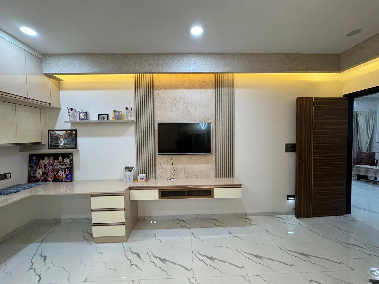 Bedroom study and television unit set against a fluted panel above a marble floor