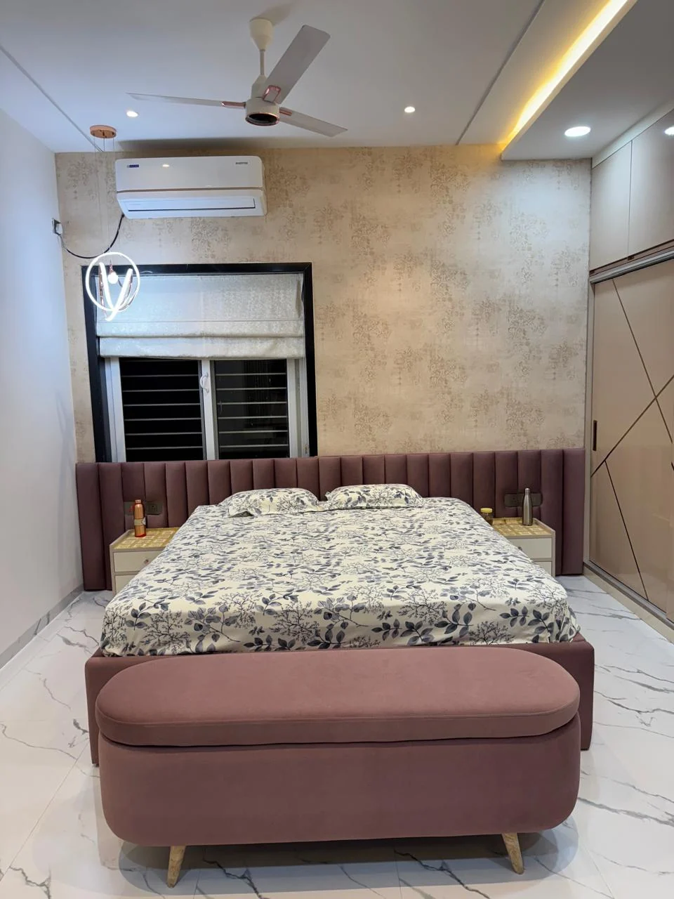 Bedroom with an upholstered tufted headboard against textured wallpaper