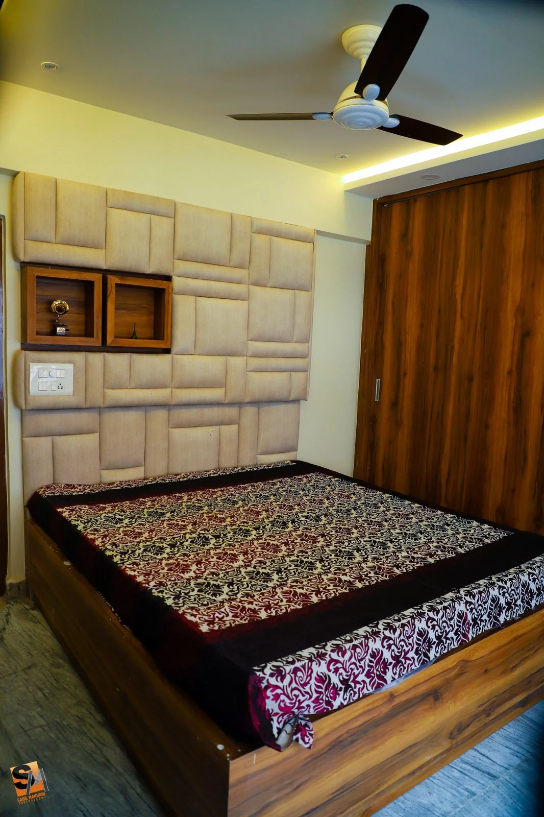 Upholstered headboard panel beside a timber wardrobe