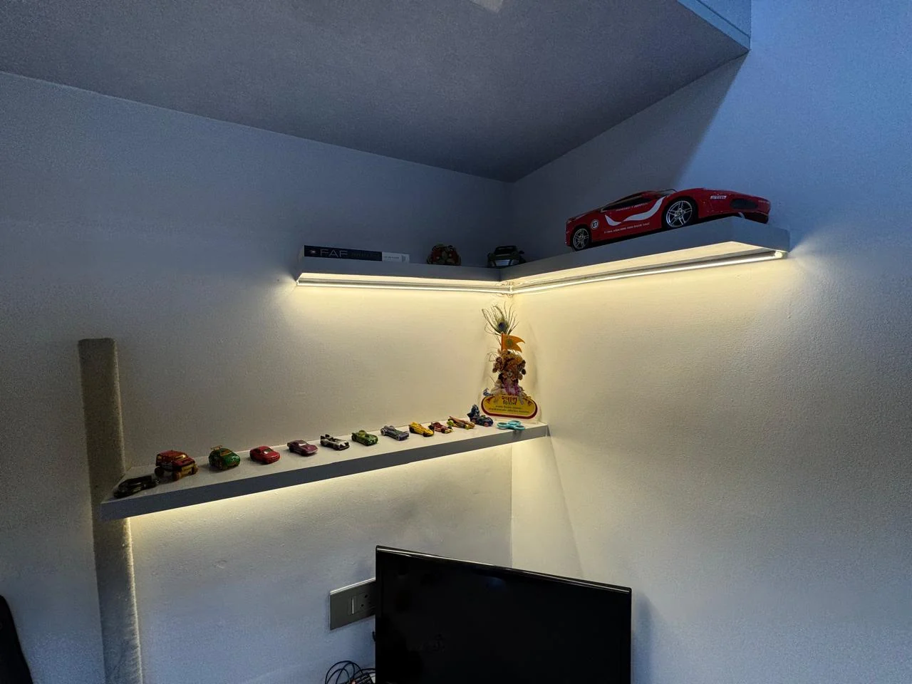 Children's bedroom display shelf set into a backlit recess