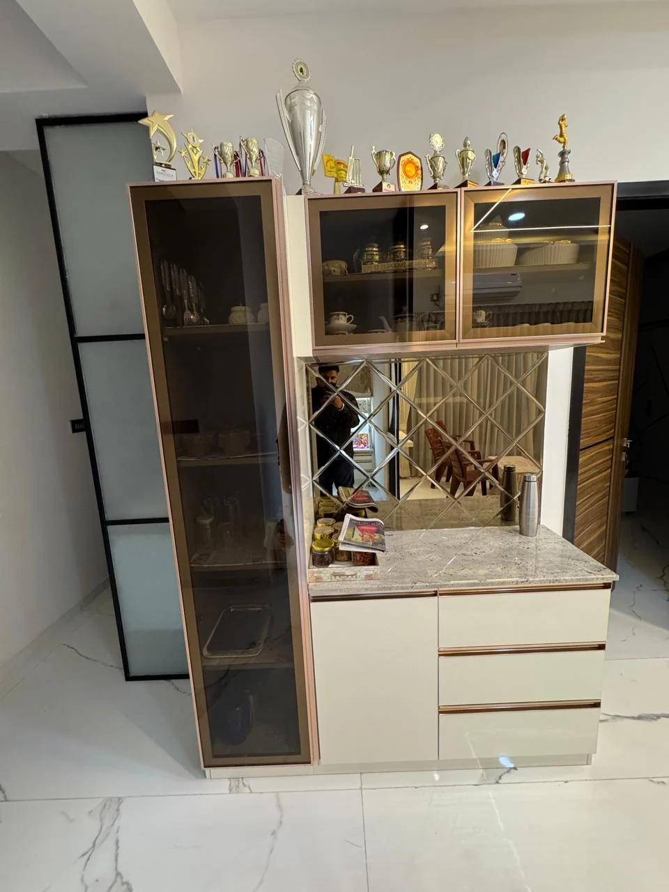Crockery unit with a mirrored back and glass shutters, lit from within
