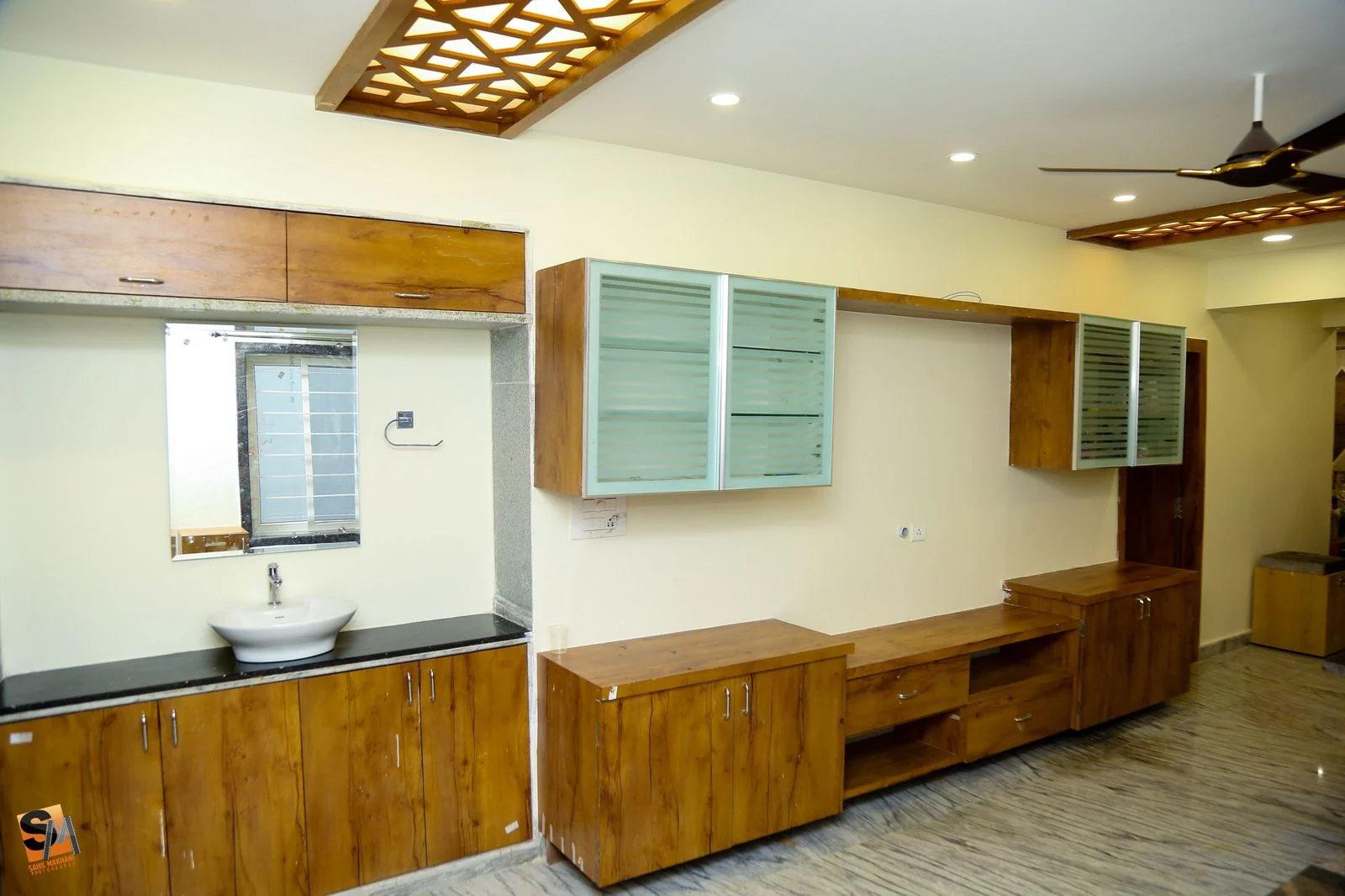 Dining washbasin counter beside a glass-fronted storage run