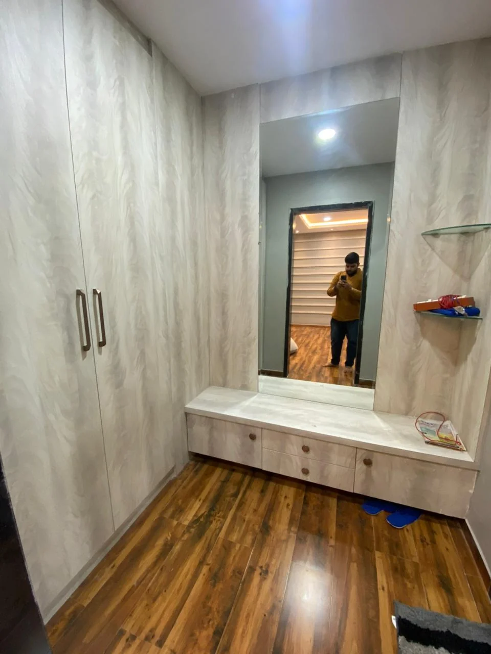 Dressing area with pale timber wardrobes, a built-in seat and drawer unit beside a full-height mirror