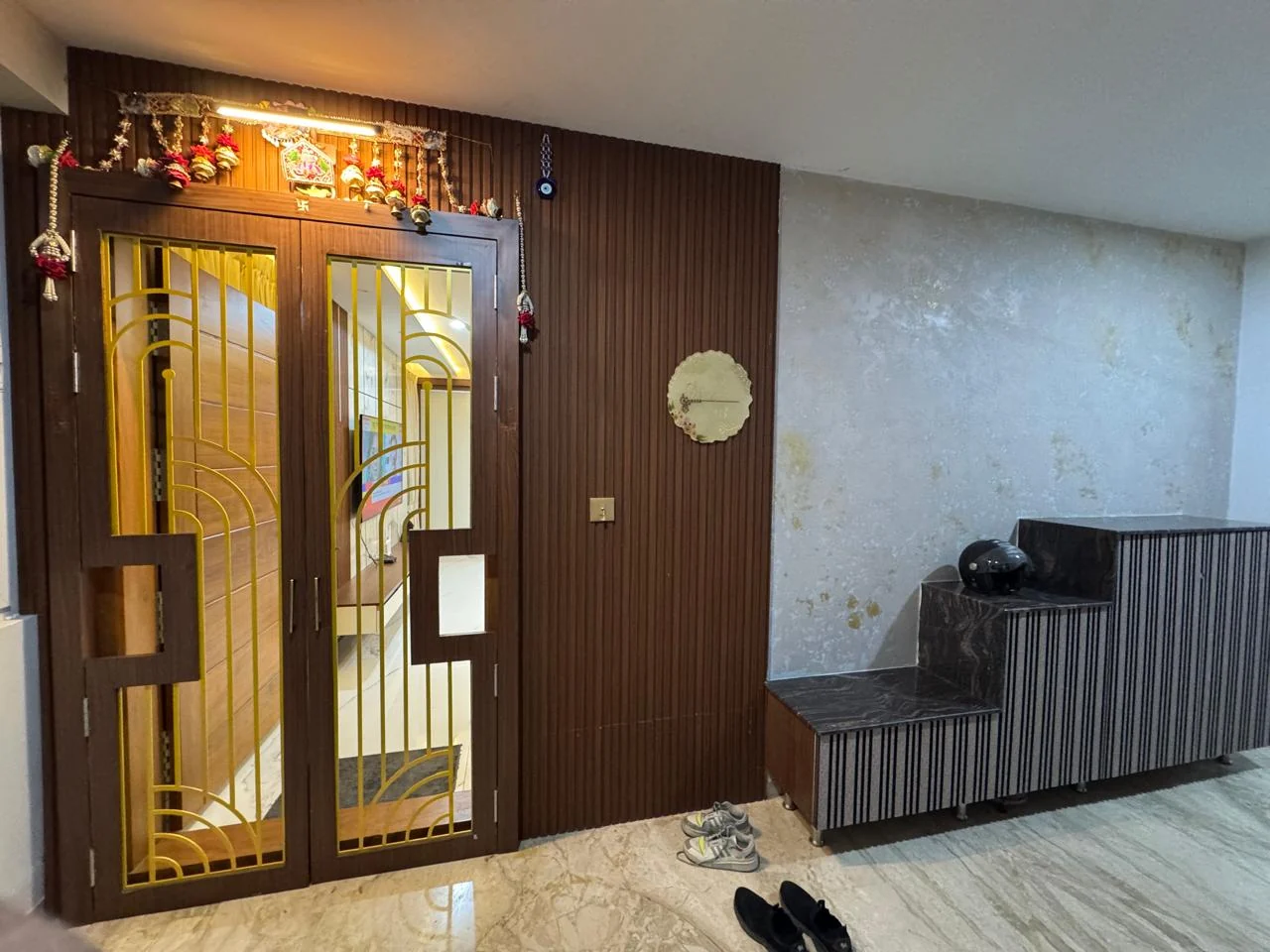 Wide view of the entrance lobby with carved timber doors and brass grille work
