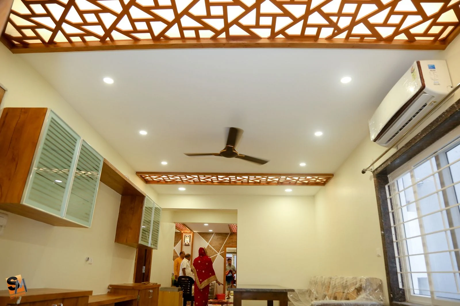 Hall fretwork ceiling beam above glass-fronted wall cabinets