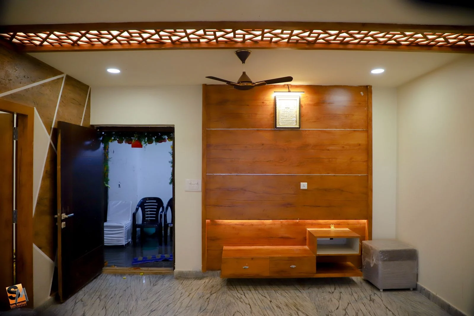 Hall with a full-height timber television panel and a backlit recess above a floating console