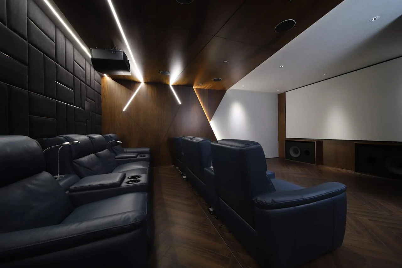 Leather recliners beneath a timber ceiling with recessed LED strips