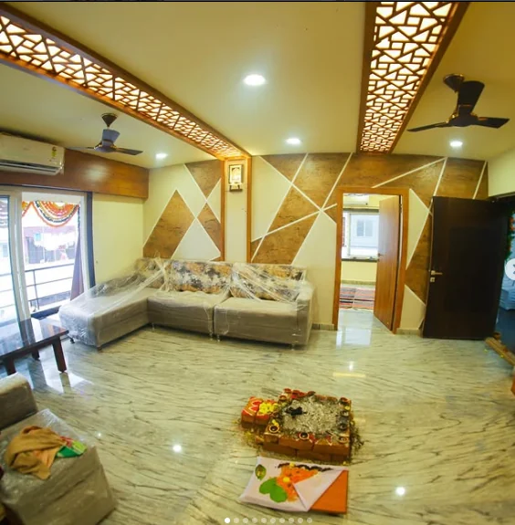 Living room with a backlit timber jaali ceiling and faceted feature wall