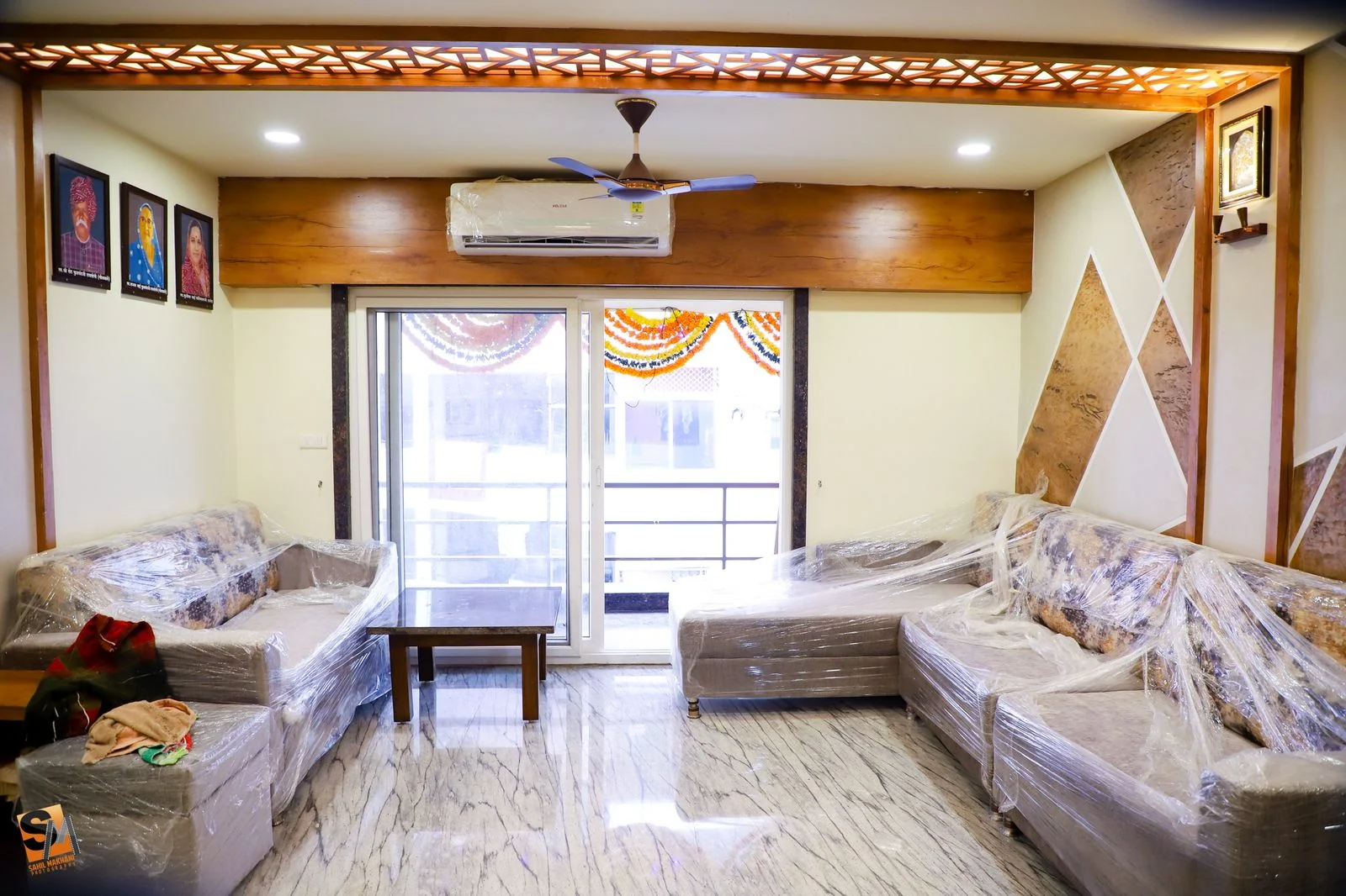 Living room sectional with framed artwork beside the balcony doors