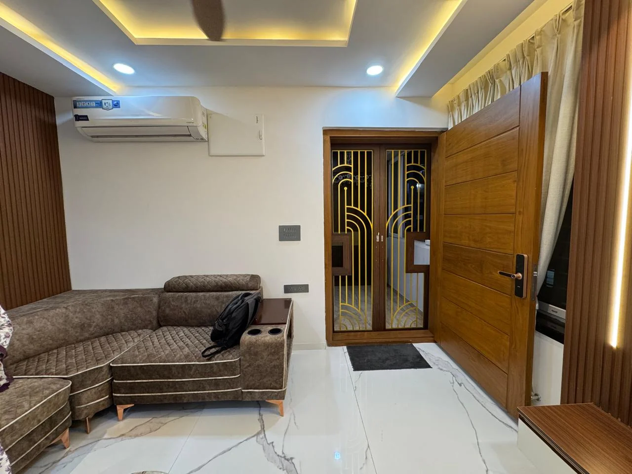 Living room styled with a deep sectional beside a carved timber entrance door