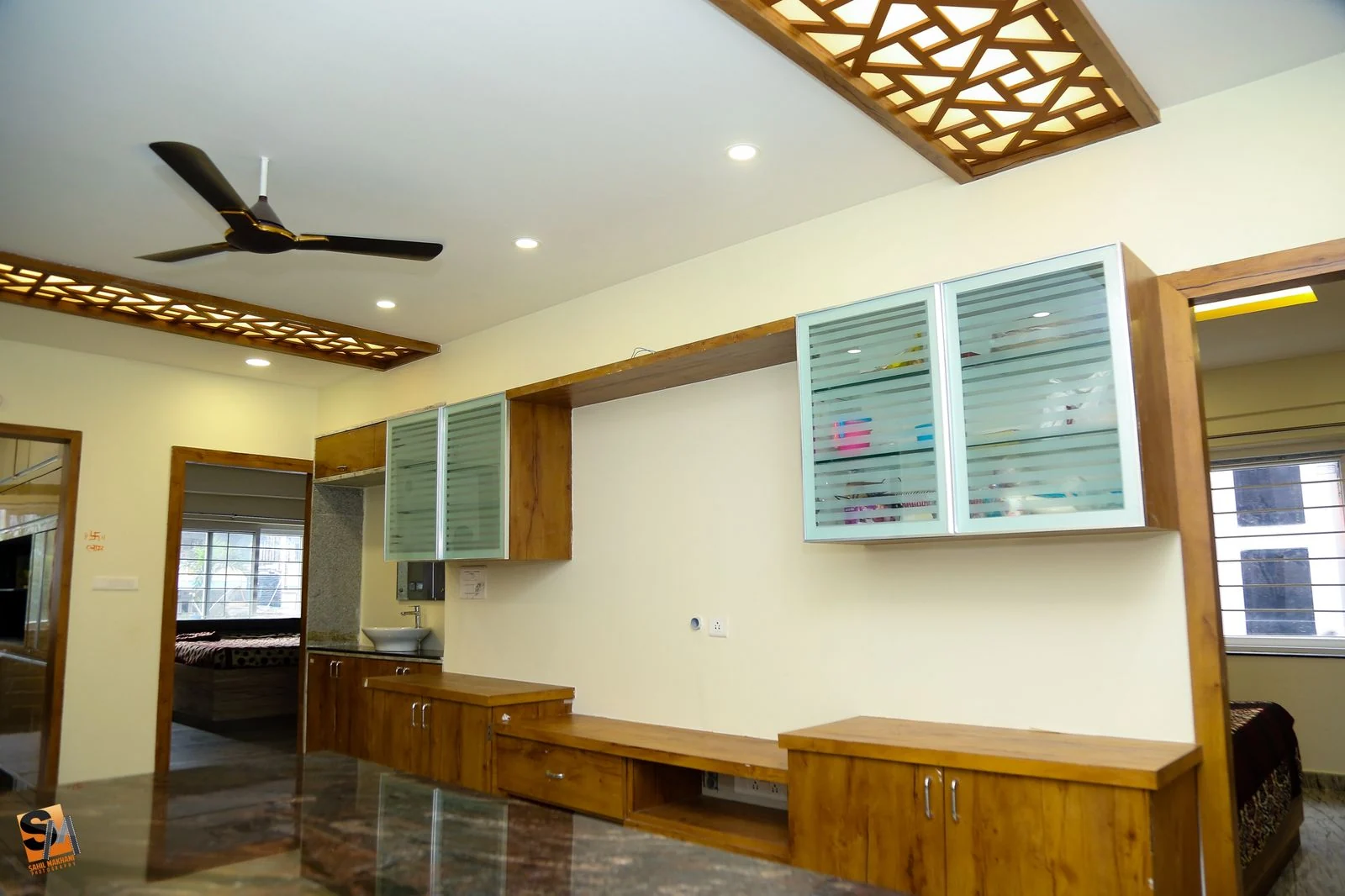 Timber media console beneath glass-fronted wall cabinets