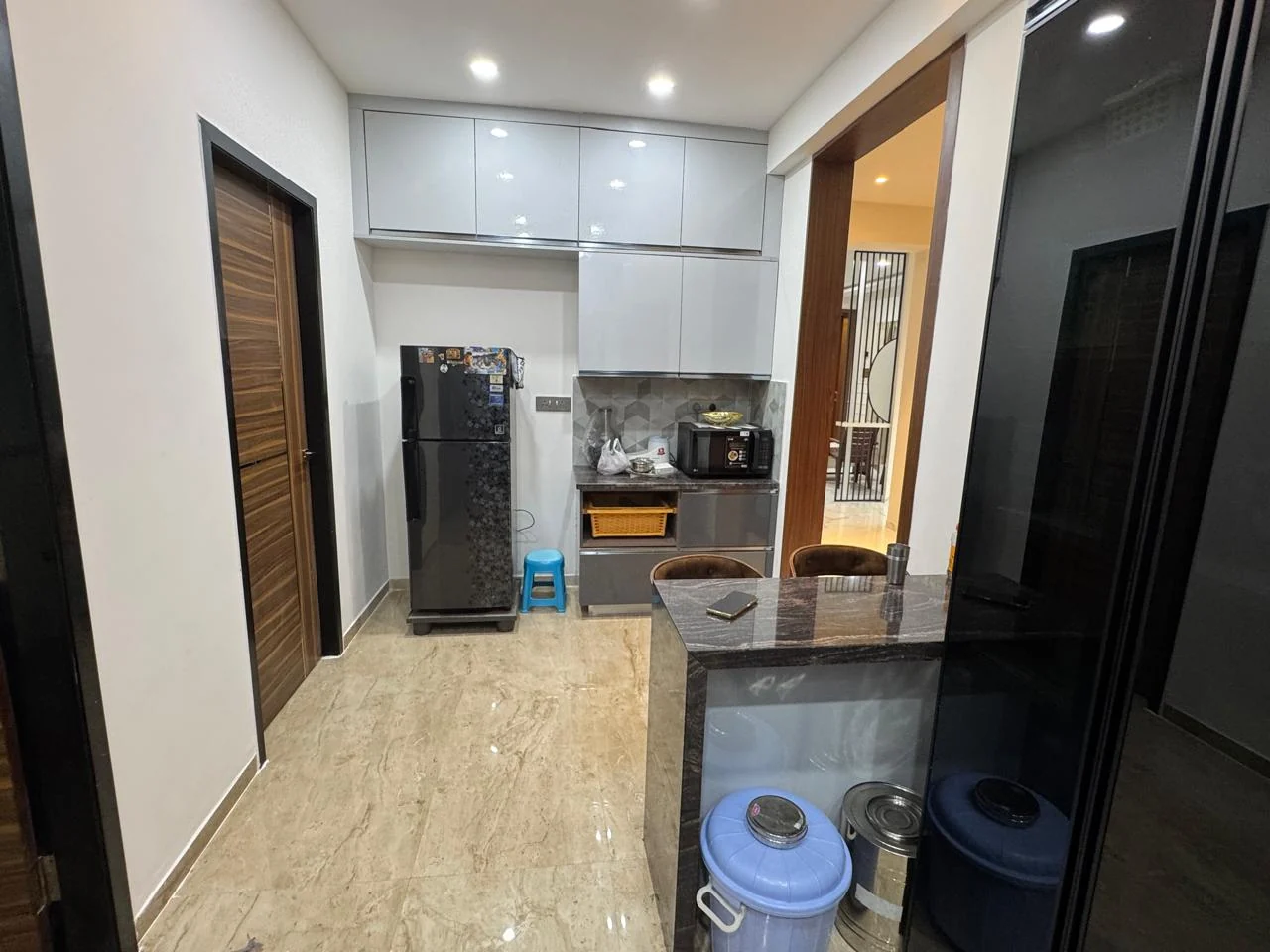 Modular kitchen seen from the passage, showing the tall storage run