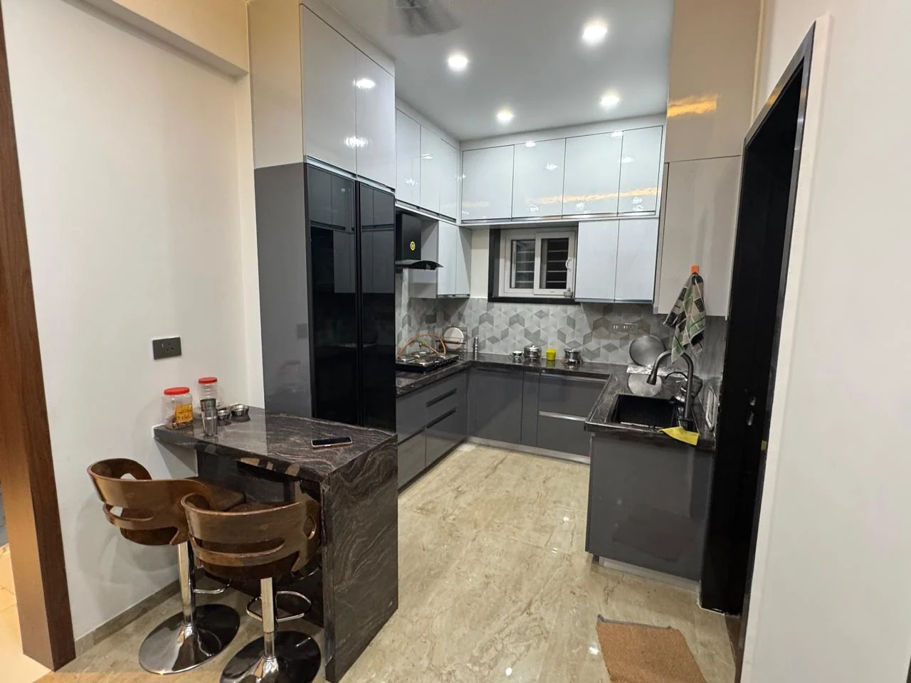 Modular kitchen in two-tone gloss with a granite breakfast bar