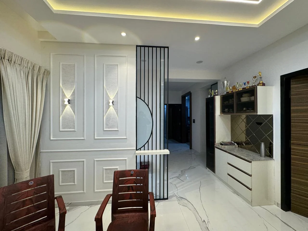 Display partition with trophy shelving dividing the hall from the passage