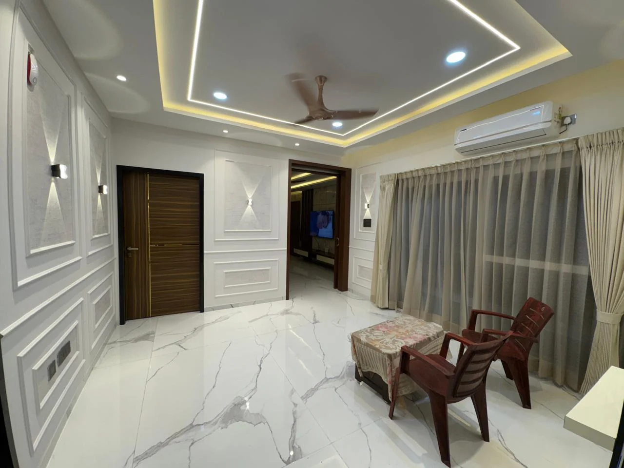 Formal hall with full-height moulded wall panelling, a curtained window and large-format marble flooring
