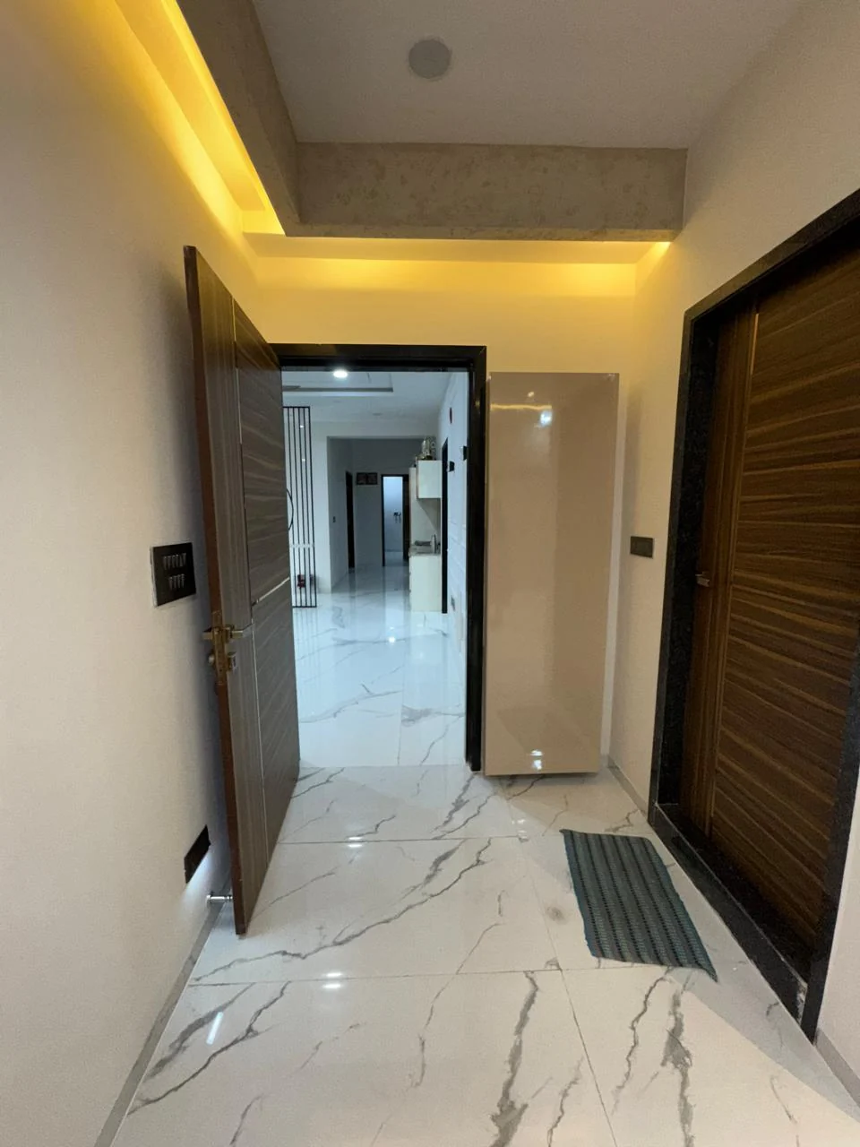 Passage with a timber door opening onto marble flooring