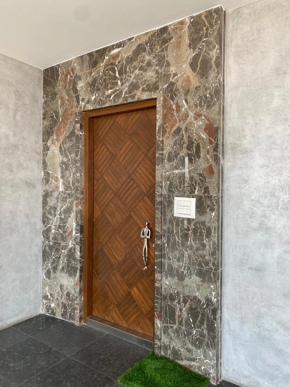 Teak parquet door leaf set between plain marble jambs