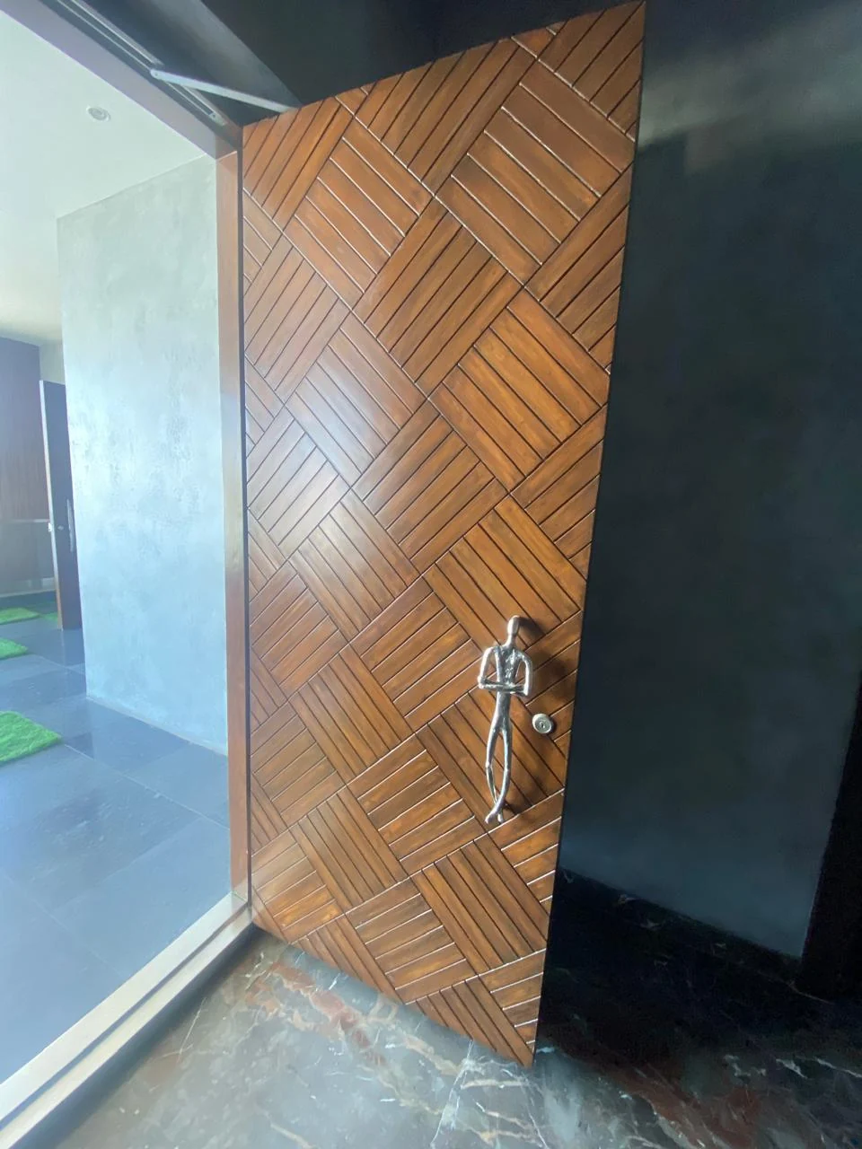 Teak parquet entrance door meeting a stone threshold