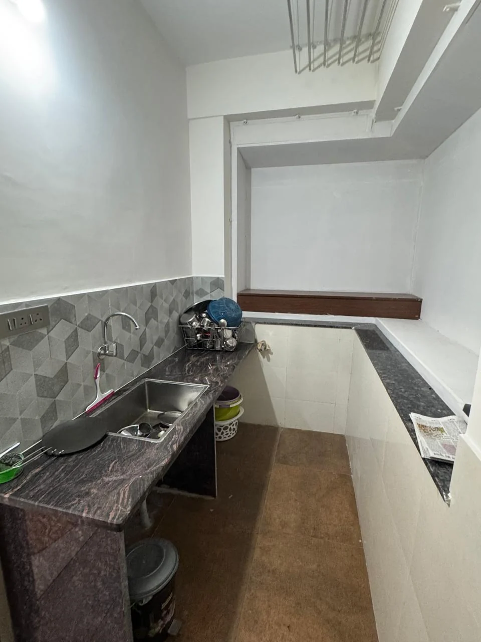 Utility area with a stainless steel sink against hexagonal tile