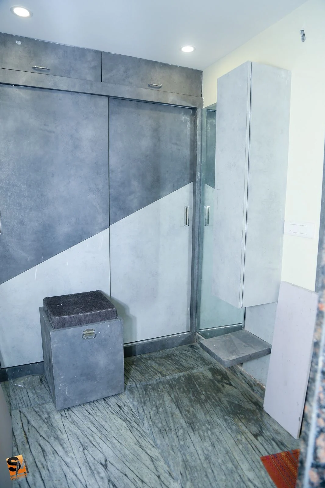 Utility area with grey laminate storage built around the washing machine